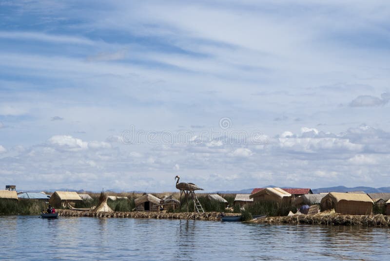 Paisagem das ilhas de flutuação de Uros nas cores azuis mágicas do lago Titicaca com a cordilheira de Andes dentro imagem de stock Paisagem das ilhas de flutuação de Uros nas cores azuis mágicas do lago Titicaca com a cordilheira de Andes dentro imagem de stock