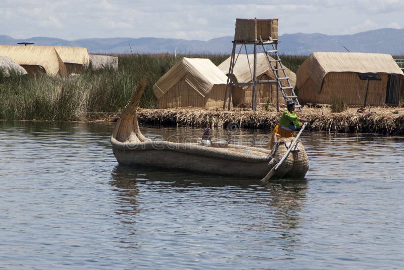 Paisagem das ilhas de flutuação de Uros nas cores azuis mágicas do lago Titicaca com a cordilheira de Andes dentro fotos de stock Paisagem das ilhas de flutuação de Uros nas cores azuis mágicas do lago Titicaca com a cordilheira de Andes dentro fotos de stock