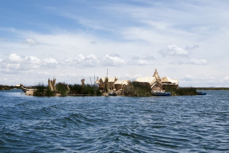 Paisagem das ilhas de flutuação de Uros nas cores azuis mágicas do lago Titicaca com a cordilheira de Andes dentro imagem de stock Paisagem das ilhas de flutuação de Uros nas cores azuis mágicas do lago Titicaca com a cordilheira de Andes dentro imagem de stock