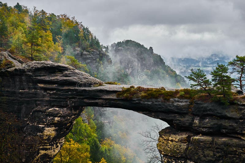 Misty foggy landscape of the Pravcicka gate Pravcicka brana the largest natural sandstone arch in Europe in Czech Switzerland Bohemian Switzerland or Ceske Svycarsko National Park. Misty foggy landscape of the Pravcicka gate Pravcicka brana the largest natural sandstone arch in Europe in Czech Switzerland Bohemian Switzerland or Ceske Svycarsko National Park.