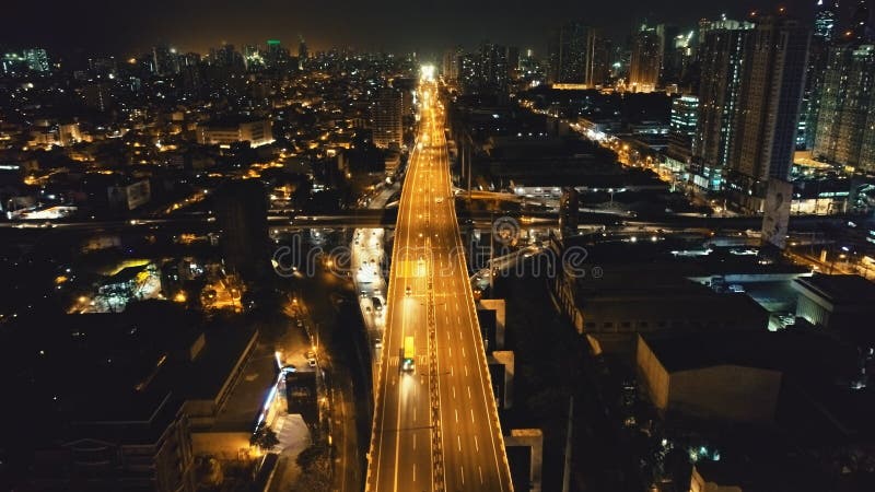 Paisagem urbana iluminada à noite com estrada de trânsito na antena do centro de negócios. luz neon da cidade do crepúsculo