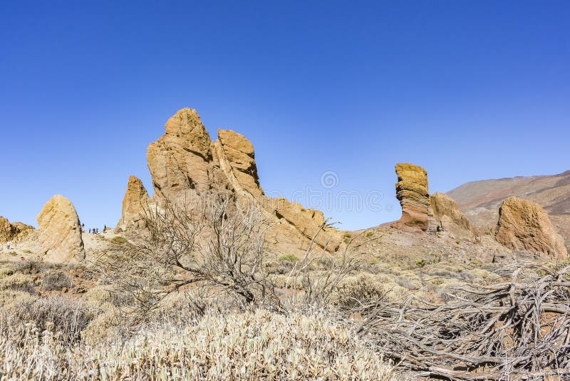 A paisagem áspera com rochas e os lotes de áspero esfregam em torno do EL Teide do vulcão na ilha de Tenerife, Espanha fotografia de stock A paisagem áspera com rochas e os lotes de áspero esfregam em torno do EL Teide do vulcão na ilha de Tenerife, Espanha fotografia de stock