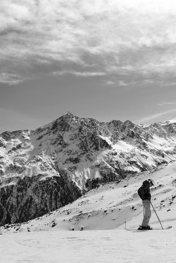 Paisaje alpino blanco y negro y el esquiador en el primero plano fotografía de archivo libre de regalías Paisaje alpino blanco y negro y el esquiador en el primero plano fotografía de archivo libre de regalías