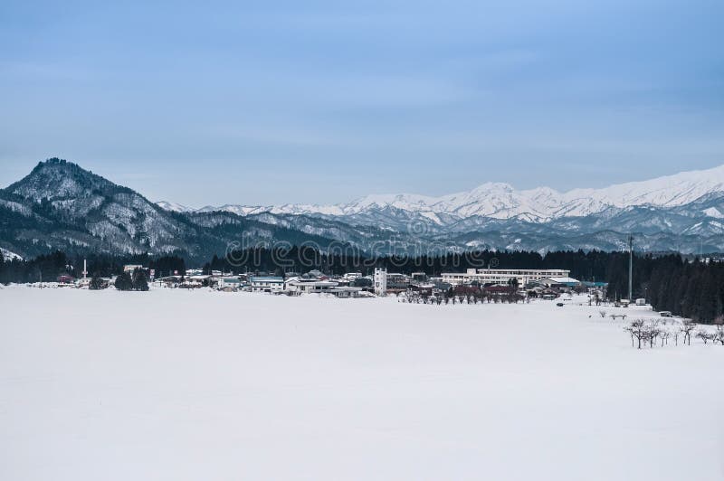 Paisaje amplio del pequeños pueblo y cordillera en Fukushima, fotografía de archivo Paisaje amplio del pequeños pueblo y cordillera en Fukushima, fotografía de archivo