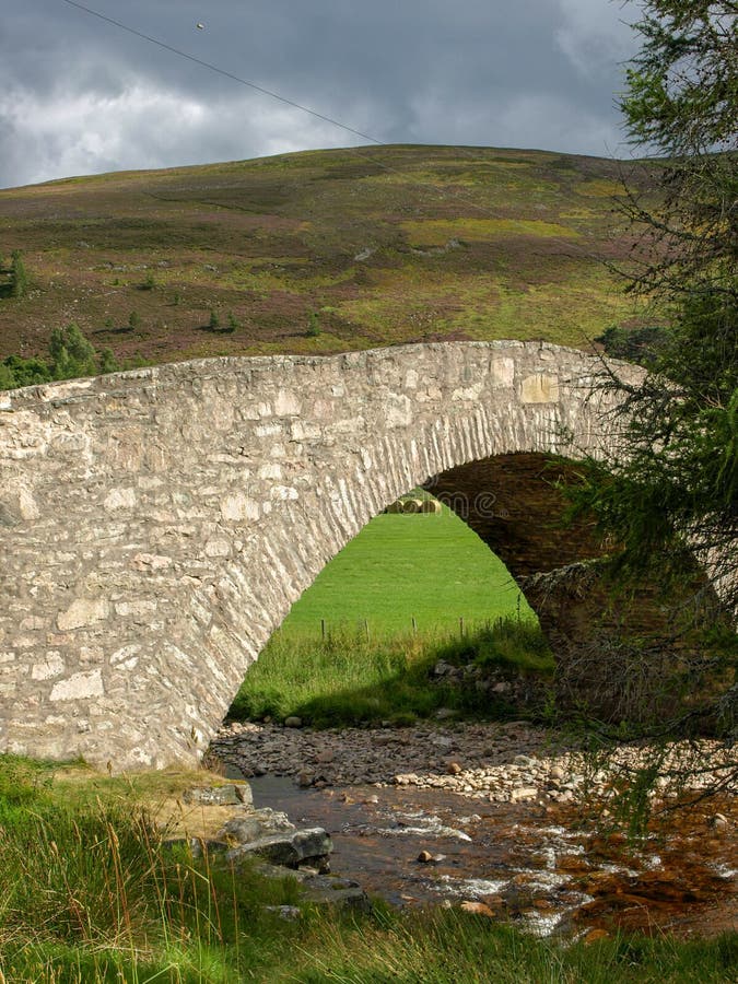 Paisaje con un bello puente de piedra arqueada. Paisaje veraniego con un hermoso puente de piedra abovedado