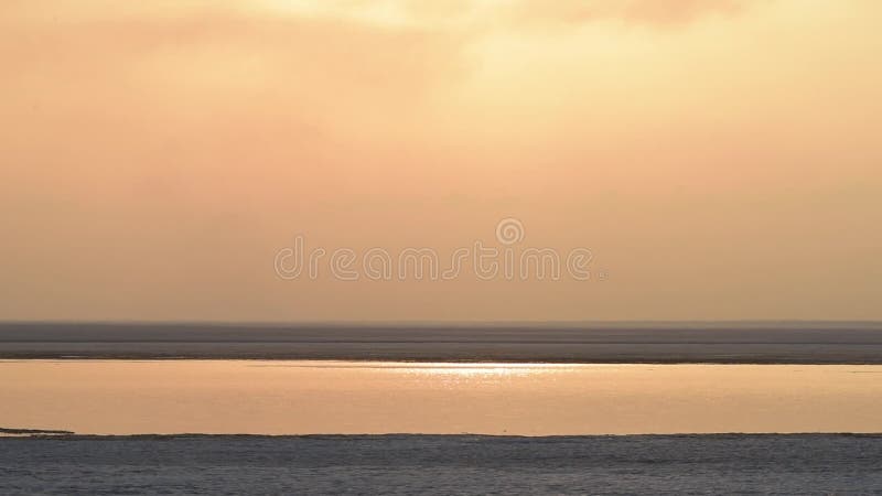 Paisaje de la primavera en el mar Fusión de la nieve Puesta del sol