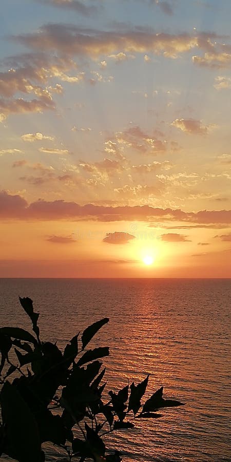 Paisaje de la puesta del sol del mar Los rayos del sol poniente perforan las nubes foto de archivo libre de regalías Paisaje de la puesta del sol del mar Los rayos del sol poniente perforan las nubes foto de archivo libre de regalías