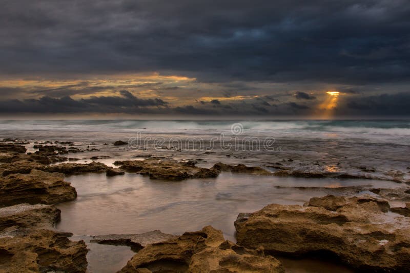 Paisaje de la salida del sol del océano con las nubes y las rocas de ondas imagen de archivo Paisaje de la salida del sol del océano con las nubes y las rocas de ondas imagen de archivo