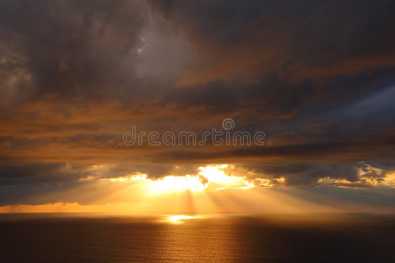 Paisaje del mar con los rayos de sol a través de las nubes