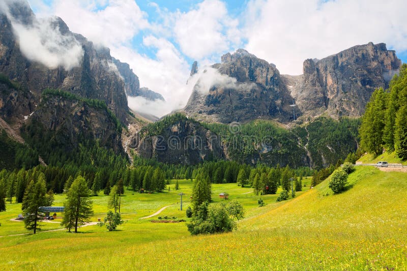 Paisaje del verano de las montañas majestuosas de Sella con las cascadas que caen abajo de los acantilados rocosos en un valle he fotografía de archivo libre de regalías Paisaje del verano de las montañas majestuosas de Sella con las cascadas que caen abajo de los acantilados rocosos en un valle he fotografía de archivo libre de regalías