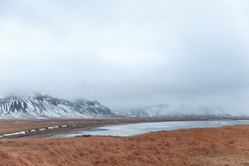 paisaje escénico hermoso con el prado, el fiordo y nevado herbosos imagen de archivo libre de regalías paisaje escénico hermoso con el prado, el fiordo y nevado herbosos imagen de archivo libre de regalías