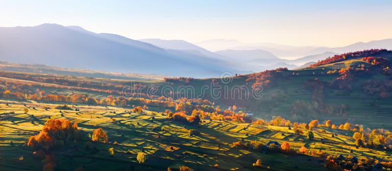 Paisaje extraordinario del otoño Campos verdes con los pajares Árboles cubiertos con las hojas anaranjadas y del carmesí Paisajes imágenes de archivo libres de regalías Paisaje extraordinario del otoño Campos verdes con los pajares Árboles cubiertos con las hojas anaranjadas y del carmesí Paisajes imágenes de archivo libres de regalías