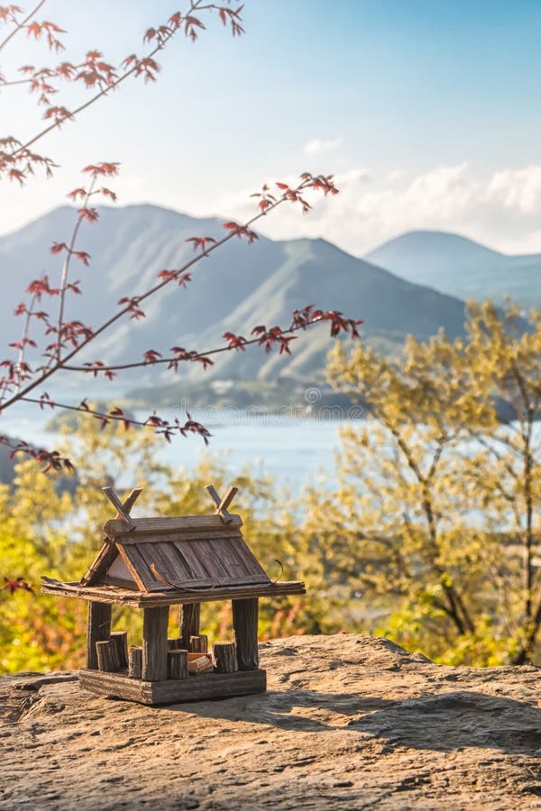 Paisaje id?lico en el Jap?n con la casa de madera tradicional del juguete y el lago hermoso con las monta?as en el fondo imagen de archivo libre de regalías Paisaje id?lico en el Jap?n con la casa de madera tradicional del juguete y el lago hermoso con las monta?as en el fondo imagen de archivo libre de regalías