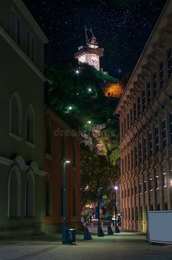 Paisaje urbano escénico de Schlossberg y de Grazer Uhrturm - torre de reloj, Graz, Austria en la noche estrellada foto de archivo libre de regalías Paisaje urbano escénico de Schlossberg y de Grazer Uhrturm - torre de reloj, Graz, Austria en la noche estrellada foto de archivo libre de regalías