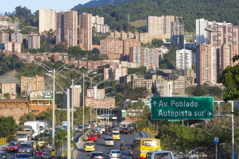 MEDELLIN, COLOMBIA, MARCH 11: Cityscape and road sign pointing the direction to Poblado district with traffic on the road. Medellin, Colombia 2015. MEDELLIN, COLOMBIA, MARCH 11: Cityscape and road sign pointing the direction to Poblado district with traffic on the road. Medellin, Colombia 2015