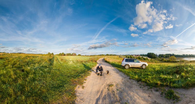 Paisaje y hombre cerca del coche con perro foto de archivo Paisaje y hombre cerca del coche con perro foto de archivo