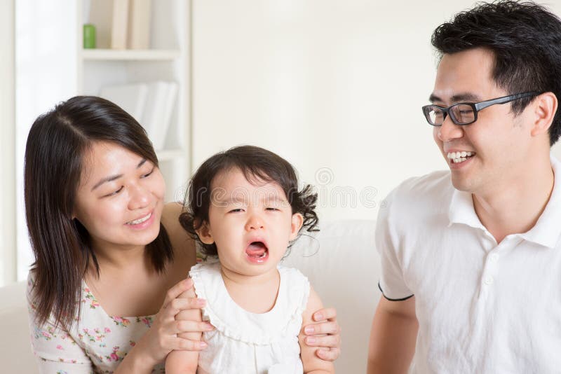 Parents is comforting their crying daughter. Asian family at home. Parents is comforting their crying daughter. Asian family at home.