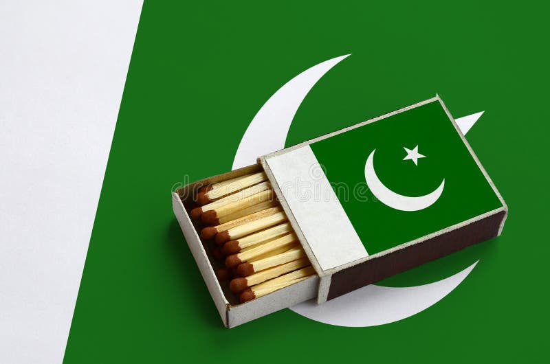 Pakistan flag is shown in an open matchbox, which is filled with matches and lies on a large flag royalty free stock photography Pakistan flag is shown in an open matchbox, which is filled with matches and lies on a large flag royalty free stock photography