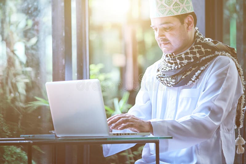 Pakistanska muslim Man arbete på bärbara datorn i kafé royaltyfria bilder Pakistanska muslim Man arbete på bärbara datorn i kafé royaltyfria bilder