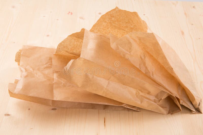 Pakować przetwarzającą Kraft papieru kieszonkę na drewnianym tle z ścinek ścieżką zdjęcia stock Pakować przetwarzającą Kraft papieru kieszonkę na drewnianym tle z ścinek ścieżką zdjęcia stock