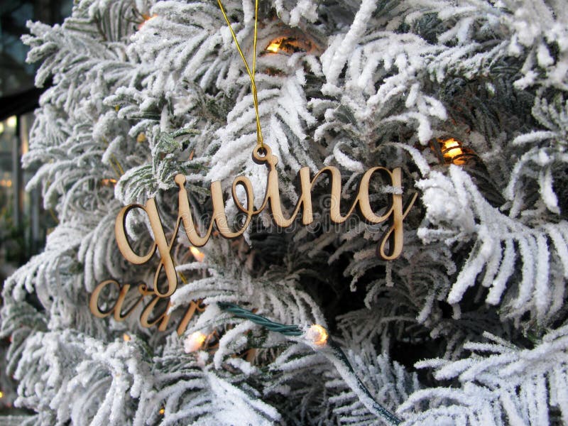 Word Giving wooden cutout Christmas decoration on white Christmas tree. Word Giving wooden cutout Christmas decoration on white Christmas tree