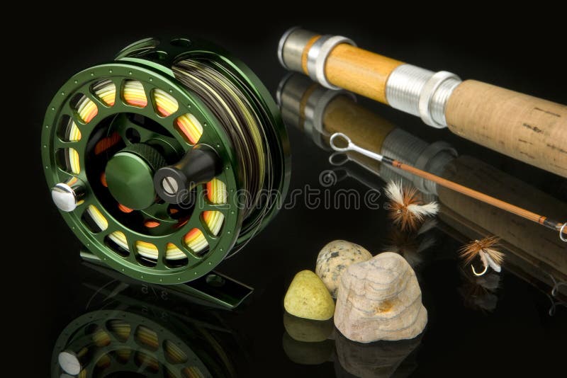 Green, metal reel a bamboo rod and two dry flies. Green, metal reel a bamboo rod and two dry flies