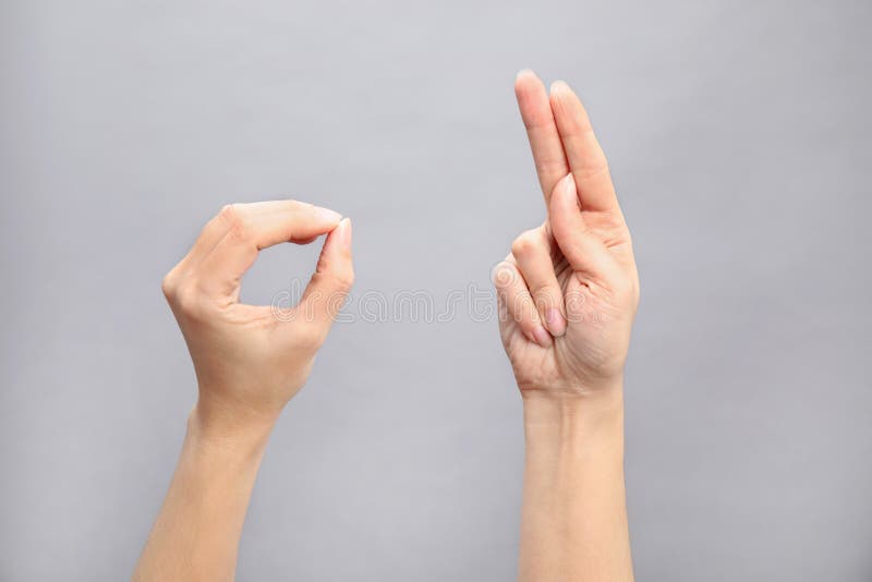 Palavra da exibição da mulher aprovada no fundo cinzento Linguagem gestual foto de stock Palavra da exibição da mulher aprovada no fundo cinzento Linguagem gestual foto de stock