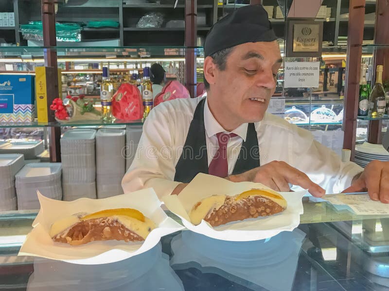 Palermo Sicily Italy June 26, 2018: Male seller in a pastry shop. Shop of Traditional Italian dessert - Sicilian cannoli royalty free stock image Palermo Sicily Italy June 26, 2018: Male seller in a pastry shop. Shop of Traditional Italian dessert - Sicilian cannoli royalty free stock image
