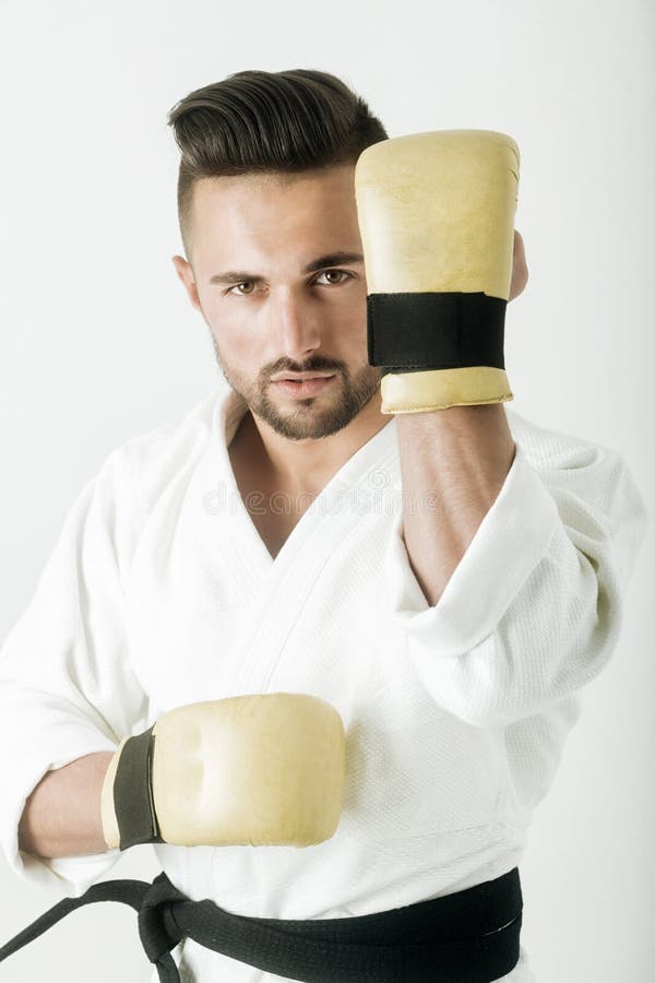 Palestra, corridoio per karatè Arti marziali orientali Guerriero attraente in kimono Sportivo bello con una barba difensivo immagine stock libera da diritti Palestra, corridoio per karatè Arti marziali orientali Guerriero attraente in kimono Sportivo bello con una barba difensivo immagine stock libera da diritti