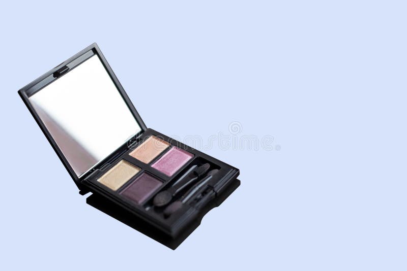 Paleta ascendente próxima da sombra para os olhos, quatro cores em tons lilás, com aplicadores Isolado no fundo azul empoeirado fotografia de stock Paleta ascendente próxima da sombra para os olhos, quatro cores em tons lilás, com aplicadores Isolado no fundo azul empoeirado fotografia de stock