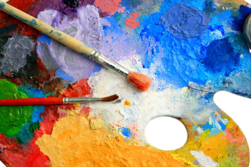 Two Brushes lay on an art palette in bright paints. Two Brushes lay on an art palette in bright paints