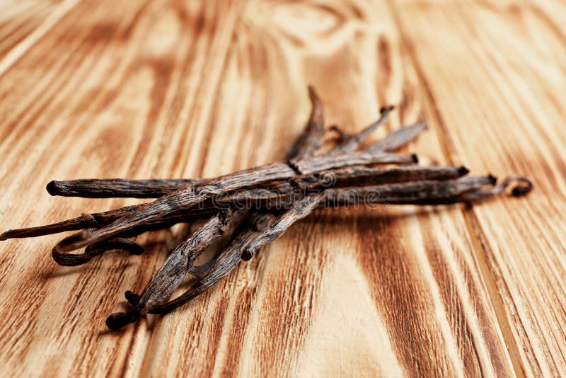 Palillos secados de la vainilla en fondo de madera imagen de archivo libre de regalías Palillos secados de la vainilla en fondo de madera imagen de archivo libre de regalías