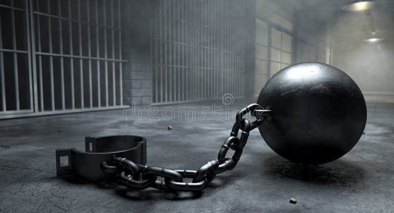 A vintage ball and chain with an open shackle on an old prison cell block floor lit by overhead lights. A vintage ball and chain with an open shackle on an old prison cell block floor lit by overhead lights