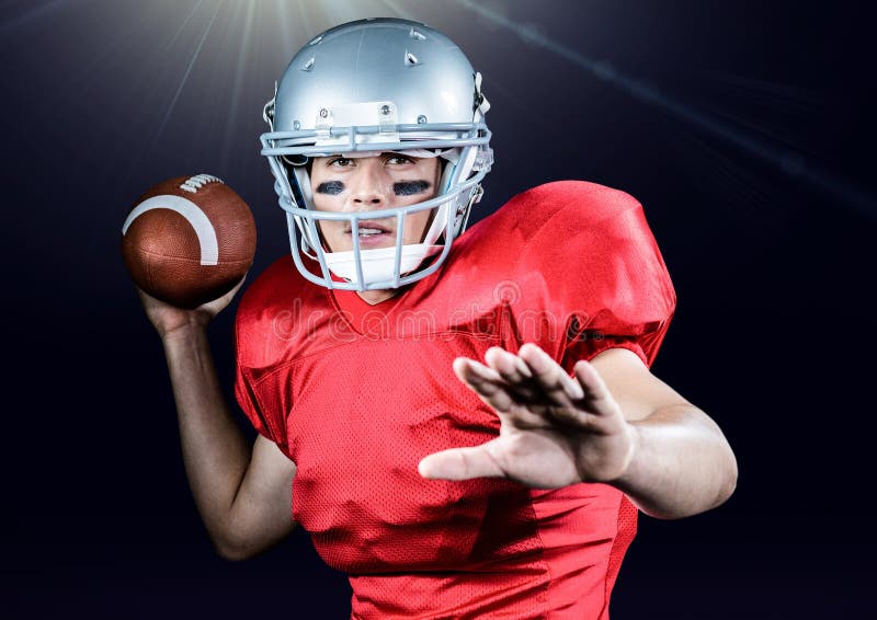 Palla di lancio del giocatore di football americano contro fondo nero fotografia stock libera da diritti Palla di lancio del giocatore di football americano contro fondo nero fotografia stock libera da diritti