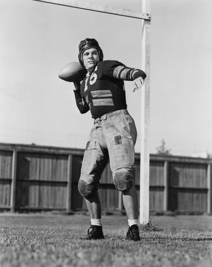 Palla di lancio del giocatore di football americano (tutte le persone rappresentate non sono vivente più lungo e nessuna propriet immagini stock libere da diritti Palla di lancio del giocatore di football americano (tutte le persone rappresentate non sono vivente più lungo e nessuna propriet immagini stock libere da diritti