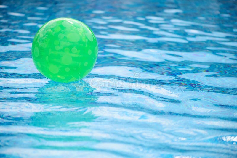 Palla verde che galleggia nella piscina immagine stock libera da diritti Palla verde che galleggia nella piscina immagine stock libera da diritti