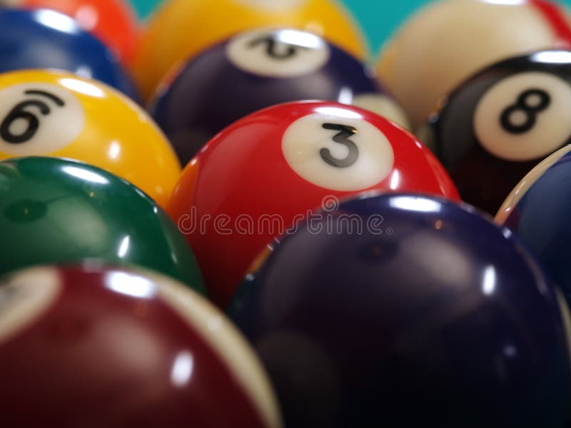 Macro photo of a pool table and billiard balls. Shallow depth of field with focus on the three ball. Macro photo of a pool table and billiard balls. Shallow depth of field with focus on the three ball.