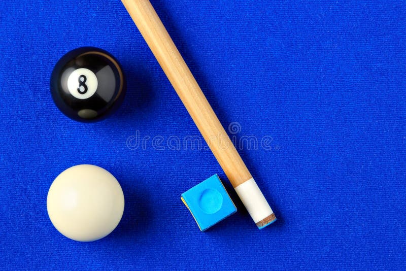 Billiard balls, cue and chalk on a blue pool table. Viewed from above. Horizontal image. Billiard balls, cue and chalk on a blue pool table. Viewed from above. Horizontal image.