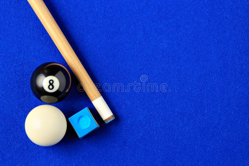 Billiard balls, cue and chalk on a blue pool table. Viewed from above. Horizontal image. Billiard balls, cue and chalk on a blue pool table. Viewed from above. Horizontal image.