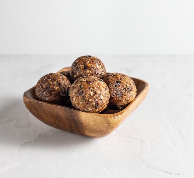 Palle di energia fatte in casa con datteri, prugne, mandorle Alimenti dolci sani Palle di energia in una ciotola di legno su fond fotografie stock Palle di energia fatte in casa con datteri, prugne, mandorle Alimenti dolci sani Palle di energia in una ciotola di legno su fond fotografie stock