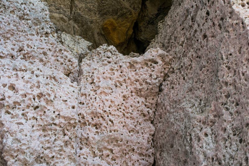 Pallido - il calcare rosa, con i fori di erosione e di alterazione causata dagli agenti atmosferici, ha trovato su un fronte dell fotografia stock Pallido - il calcare rosa, con i fori di erosione e di alterazione causata dagli agenti atmosferici, ha trovato su un fronte dell fotografia stock