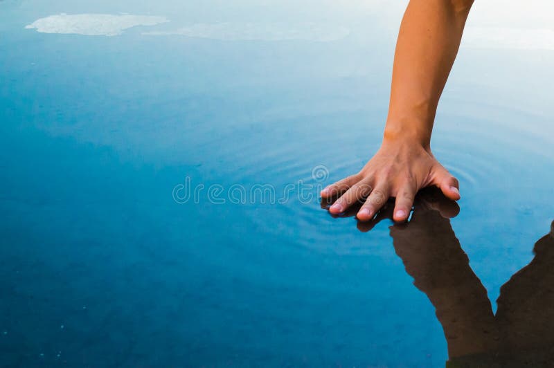 A hand stroke the water