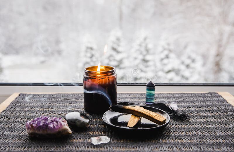 Palo Santo wood known as oily aromatic holy wood sticks smouldering on plate on home window sill cleaning negative energy concept.