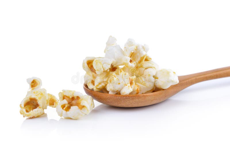 Palomitas en la cuchara de madera aislada en el fondo blanco fotos de archivo Palomitas en la cuchara de madera aislada en el fondo blanco fotos de archivo