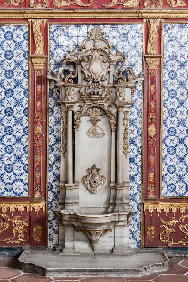 A marble sink with golden adornments and a wall with blue patterned tiles in Topkapi palace, Istanbul, Turkey. A marble sink with golden adornments and a wall with blue patterned tiles in Topkapi palace, Istanbul, Turkey.