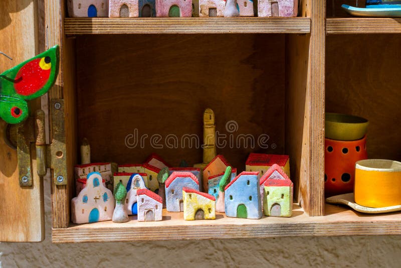 Rethymno, Greece - May 3, 2016: Handmade souvenir clay houses in window of tourist resort store. Resort classic Greek architecture in port-city Rethymno. Crete, Greece. Rethymno, Greece - May 3, 2016: Handmade souvenir clay houses in window of tourist resort store. Resort classic Greek architecture in port-city Rethymno. Crete, Greece