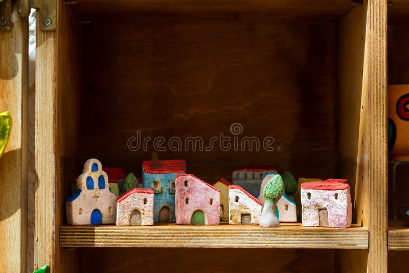 Rethymno, Greece - May 3, 2016: Handmade souvenir clay houses in window of tourist resort store. Resort classic Greek architecture in port-city Rethymno. Crete, Greece. Rethymno, Greece - May 3, 2016: Handmade souvenir clay houses in window of tourist resort store. Resort classic Greek architecture in port-city Rethymno. Crete, Greece