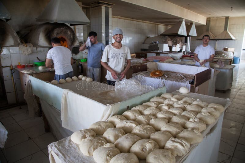 Pan de pan hecho por panaderos jóvenes en una panadería en Taskent imagenes de archivo Pan de pan hecho por panaderos jóvenes en una panadería en Taskent imagenes de archivo