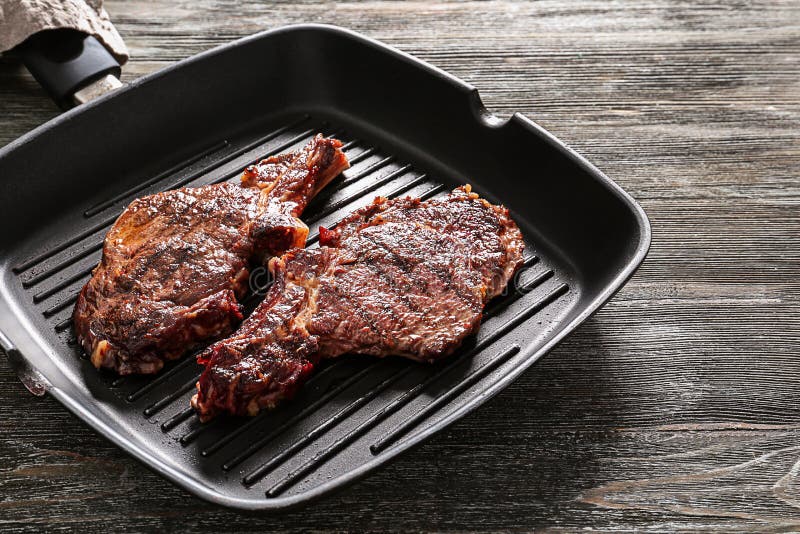Pan with Delicious Grilled Steaks on Wooden Table Stock Image Image