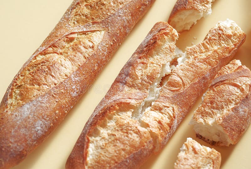Pan franc?s tradicional Tres baguettes recientemente cocidos que ponen en el contexto amarillo fotos de archivo Pan franc?s tradicional Tres baguettes recientemente cocidos que ponen en el contexto amarillo fotos de archivo